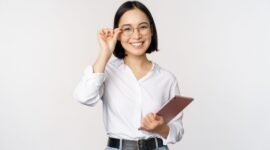 Image of young asian business woman, female entrepreneur in glasses, holding tablet and looking professional in glasses, white background.