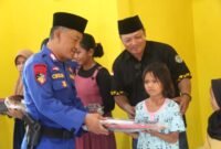 Anggota Sat Polairud Polres Lampung Timur bersama Ketua IWO Lampung Timur Andono, saat menyerahkan bantuan ke anak di Musala Kampung Nelayan, Desa Margasari, Kecamatan Labuhan Maringgai, Selasa 2 April 2024. Sumber: Humas IWO Lamtim.