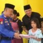 Anggota Sat Polairud Polres Lampung Timur bersama Ketua IWO Lampung Timur Andono, saat menyerahkan bantuan ke anak di Musala Kampung Nelayan, Desa Margasari, Kecamatan Labuhan Maringgai, Selasa 2 April 2024. Sumber: Humas IWO Lamtim.