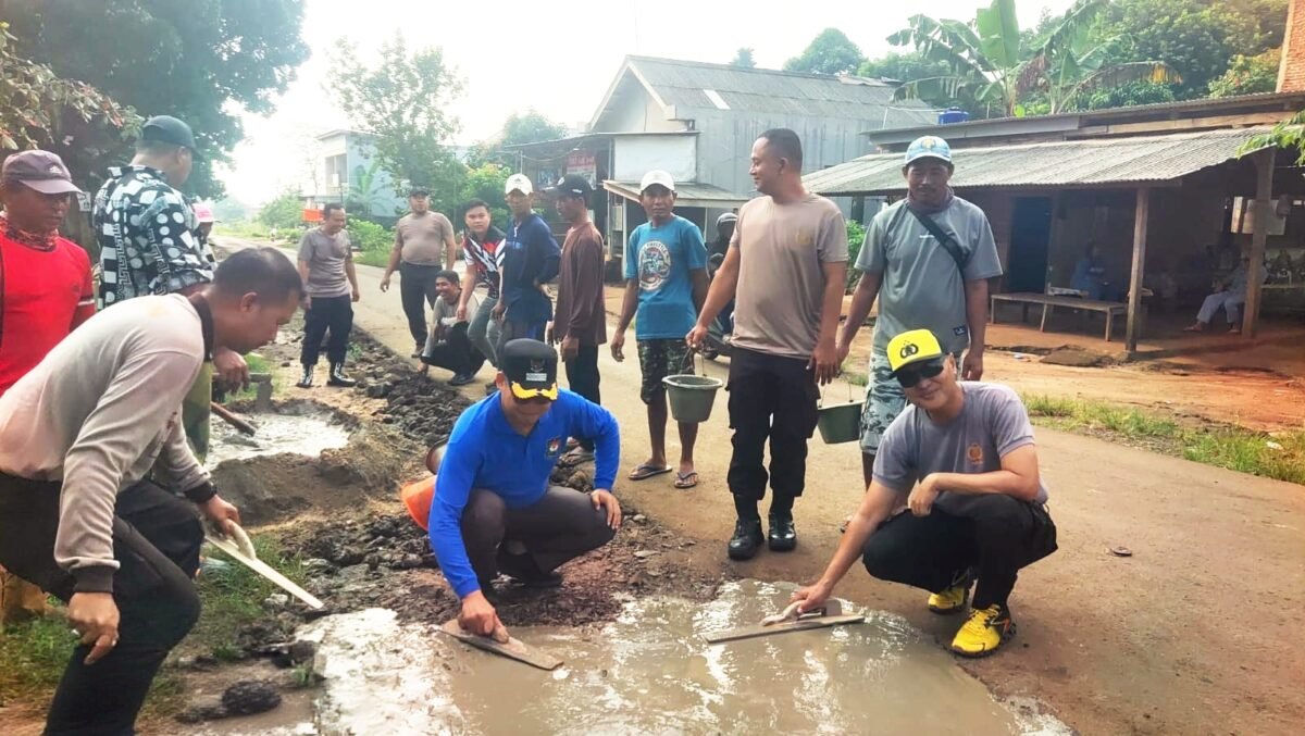 Suasana saat polisi dan warga bahu membahu perbaiki jalan di Sriminosari, Labuhan Maringgai pada Jumat pagi (15/5)./ Jahri