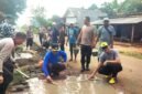 Suasana saat polisi dan warga bahu membahu perbaiki jalan di Sriminosari, Labuhan Maringgai pada Jumat pagi (15/5)./ Jahri