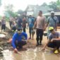 Suasana saat polisi dan warga bahu membahu perbaiki jalan di Sriminosari, Labuhan Maringgai pada Jumat pagi (15/5)./ Jahri
