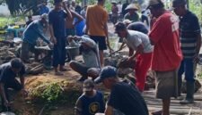 Puluhan warga saat bergotong royong memperbaiki jembatan./M. Jahri