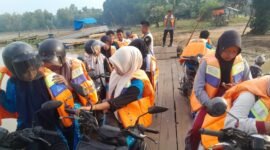 Para pelajar yang menyeberangi sungai Way Bungur mengenakan pelampung dengan didampingi polisi./Ist