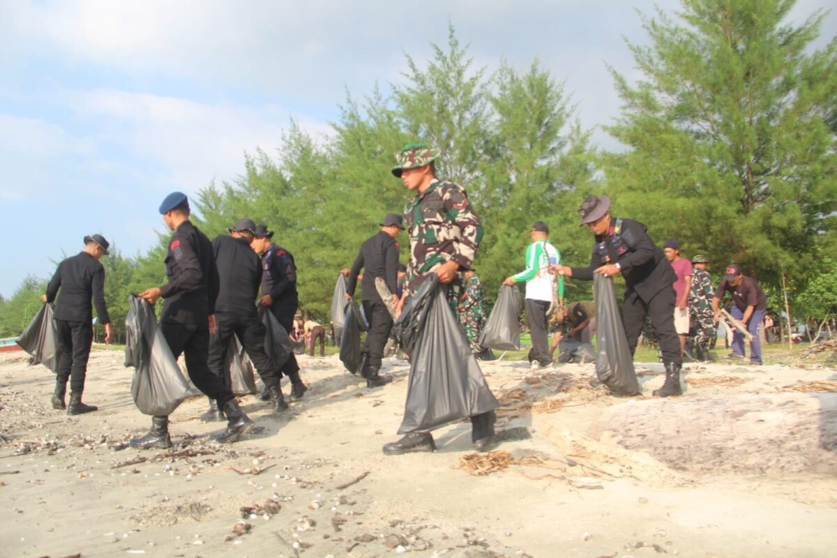 Personel TNI, Polri, Pramuka, mahasiswa, dan masyarakat bergotong royong membersihkan sampah di kawasan Pantai Mutiara Baru, Kecamatan Labuhan Maringgai, Lampung Timur, Jumat (10/7/2027). Kegiatan tersebut merupakan bagian dari Program Gerakan Radin Inten Asri yang digelar serentak sebagai upaya menjaga kebersihan dan kelestarian lingkungan pesisir. (Dok: Agus S)