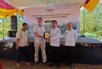 Keterangan Foto:Perwakilan PT Olam Food Ingredients (OFI) bersama Pemerintah Provinsi Lampung menyerahkan cendera mata usai peluncuran Program Inisiasi Regeneratif MUK–Restorasi Lanskap Perhutanan Sosial di Desa Sri Josari, Kecamatan Way Jepara, Lampung Timur, Rabu (15/7/2026). Program ini bertujuan memperkuat konservasi hutan melalui perhutanan sosial dan pengembangan agroforestri berkelanjutan. (Foto: Agus S)