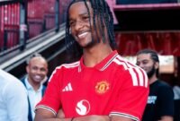 Tynan Thompson berpose mengenakan jersey Manchester United setelah resmi bergabung dari Tottenham Hotspur. Winger muda berusia 18 tahun itu dikontrak Setan Merah dalam transfer yang nilainya berpotensi mencapai 8 juta poundsterling. (Foto: Instagram/tynan_tt)